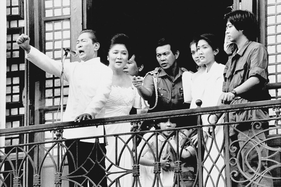Ferdinand Marcos holdt sin siste tale til folket fra balkongen i presidentpalasset før han rømte landet i februar 1986. Kona hans Imelda står bak ham, lengst til høyre står Ferdinand Marcos junior som nå blir Filippinenes nye president. Ferdinand Marcos holdt sin siste tale til folket fra balkongen i presidentpalasset før han rømte landet i februar 1986. Kona hans Imelda står bak ham, lengst til høyre står Ferdinand Marcos junior som nå blir Filippinenes nye president.