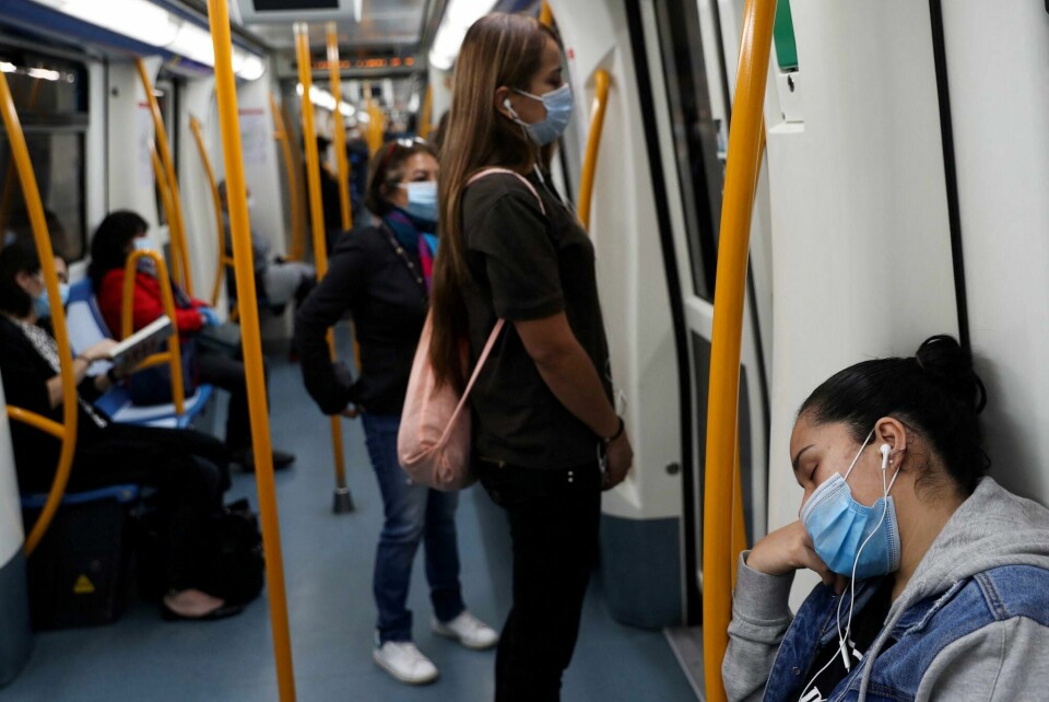Nå er det slutt på bruk av munnbind på offentlige transportmidler i Spania. Arkivfoto. FILE PHOTO: A commuter wearing a protective mask sleeps inside a metro coach, on the first day mask usage is mandatory in public transport, amid the coronavirus disease (COVID-19) outbreak in Madrid, Spain, May 4, 2020. REUTERS/Susana Vera/File Photo