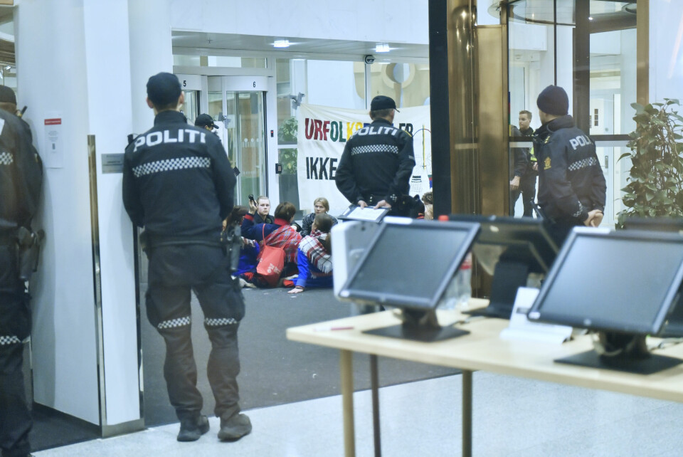 Politiet er på plass for å fjerne aktivistene som demonstrerer inne i resepsjonen til Olje- og energidepartementet. De demonstrerer mot vindturbinene på Fosen. Det er ifølge politiet 13 aktivister inne i bygningen. Foto: Rodrigo Freitas / NTB