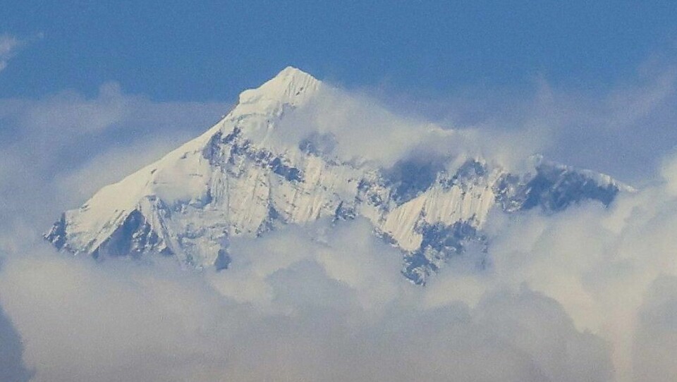 Mount Everest strekker seg 8.849 meter over havet. Mount Everest toppen stikker ut fordi skyene.