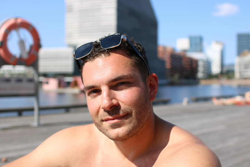 Adam Rusnak har badet på Sørenga i mange år. Han er ikke bekymret for badevannskvaliteten. En mann i slutten av 20 årene med solbriller på hodet.