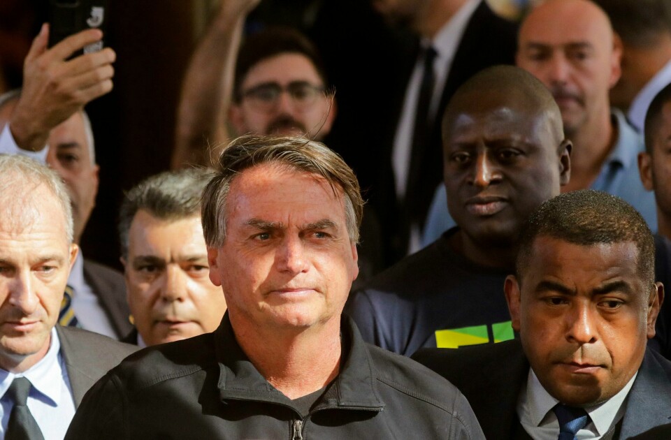 Jair Bolsonaro kan bli utestengt fra brasiliansk politikk resten av tiåret dersom flertallet følger den førstvoterende dommeren. Brasils ekspresident Jair Bolsonaro (midten) risikerer å miste retten til å stille til valg. Foto: Gustavo Moreno / AP / NTB