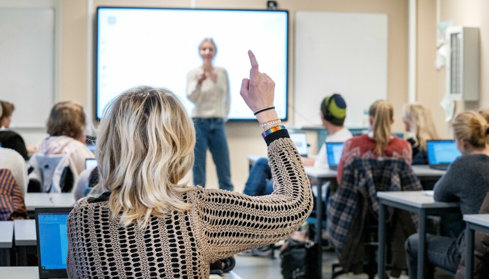 Ifølge Norges Astma- og allergiforbund (NAAF) har enkelt norske ungdommer vapet siden barneskolen, og noen er blitt så avhengig av nikotin at de føler trang til å gå ut midt i skoletimen for å vape. Illustrasjonsfoto: Bildet viser et klasserom fylt med elever. Læreren peker ut i rommet. En elev rekker opp hånden. Foto: Gorm Kallestad / NTB