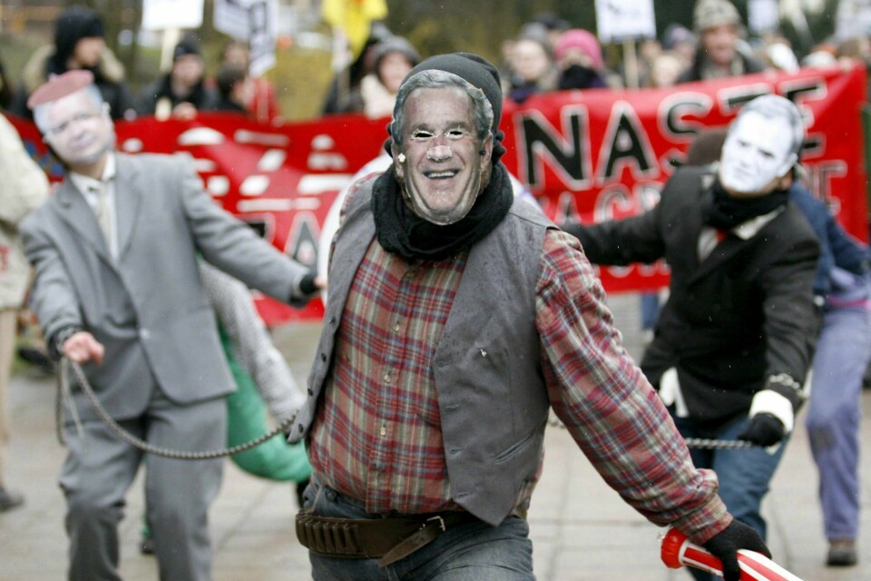 Rakettbasen har vært under bygging i lang tid, og det har også vært protester mot byggingen. Bildet er fra mars 2008, der demonstranter har på seg masker av USAs daværende president George W. Bush og Donald Tusk, som var statsminister både da og nå. Rakettbasen har vært under bygging i lang tid, og det har også vært protester mot byggingen. Bildet er fra mars 2008, der demonstranter har på seg masker av USAs daværende president George W. Bush og Donald Tusk, som var statsminister både da og nå. Arkivfoto: AP / NTB