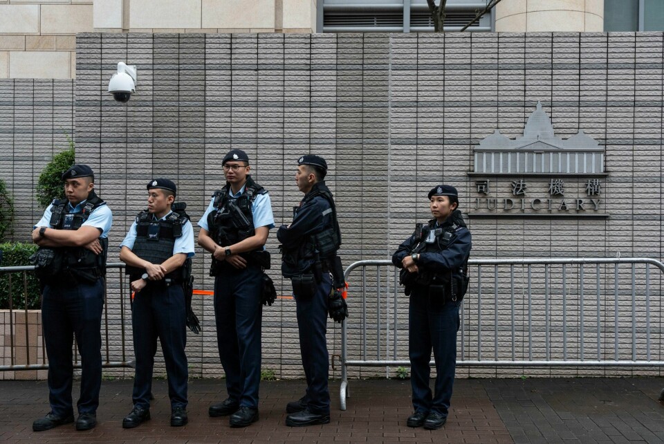 Politibetjenter holder vakt utenfor domstolen i Hongkong der 45 demokratiaktivister tirsdag ble fengselsdømt. Politibetjenter holder vakt utenfor domstolen i Hongkong der 45 demokratiaktivister tirsdag ble fengselsdømt. Foto: Chan Long Hei / AP / NTB