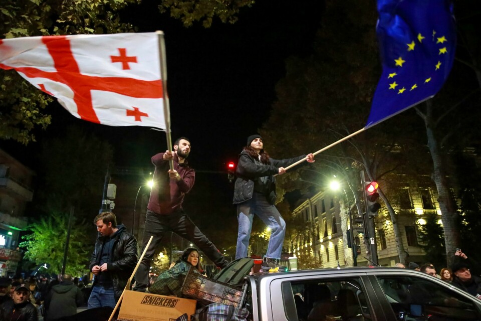Demonstranter veiver med Georgias flagg og EU-flagget under en demonstrasjon i Tbilisi. Det har vært store demonstrasjoner etter valget i oktober, som opposisjonen mener var illegitimt. Natt til tirsdag barket politi og demonstranter sammen, ifølge det russiske statlige nyhetsbyrået Tass. Demonstranter veiver med Georgias flagg og EU-flagget under en demonstrasjon i Tbilisi. Det har vært store demonstrasjoner etter valget i oktober, som opposisjonen mener var illegitimt. Natt til tirsdag barket politi og demonstranter sammen, ifølge det russiske statlige nyhetsbyrået Tass. Foto: Zurab Tsertsvadze / AP / NTB
