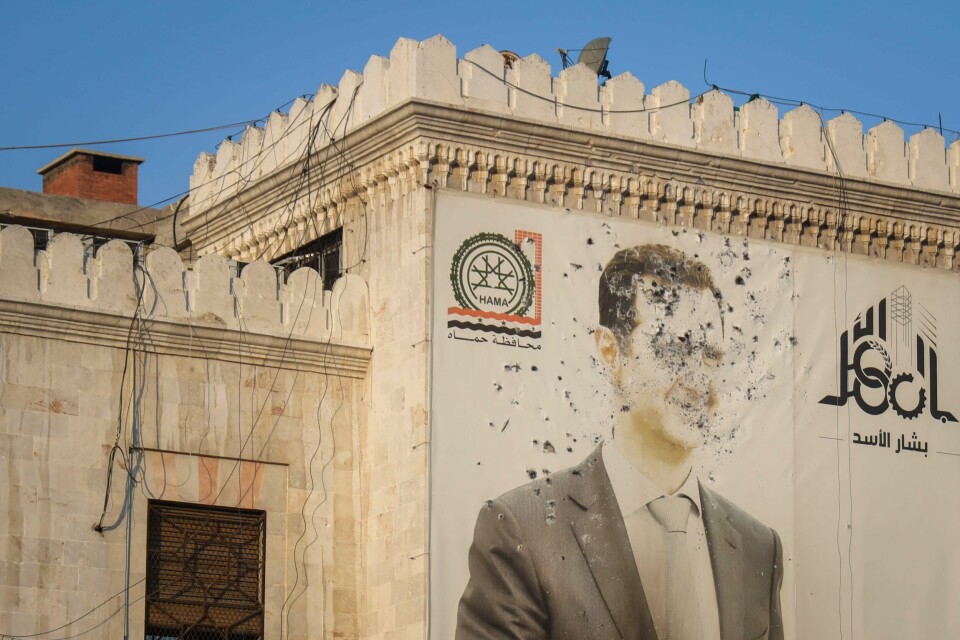 Et portrett av president Bashar al-Assad er ødelagt av kuleregn i Hama i Syria. Meldinger lørdag går ut på at opprørere nærmer seg Damaskus. Et portrett av president Bashar al-Assad er ødelagt av kuleregn i Hama i Syria. Meldinger lørdag går ut på at opprørere nærmer seg Damaskus. Foto: Omar Albam / AP / NTB