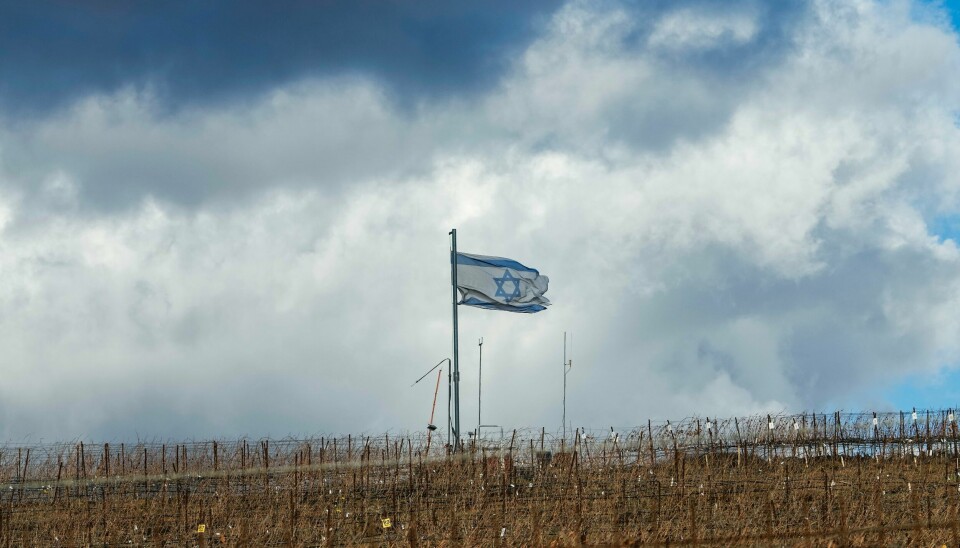 Et israelsk flagg flagrer i nærheten av Golanhøydene fredag 13. desember. Et israelsk flagg er heist i nærheten av den såkalte Alpha-linjen, som går mellom Syria og de israelskokkuperte Golanhøydene. Foto: Matias Delacroix / AP / NTB