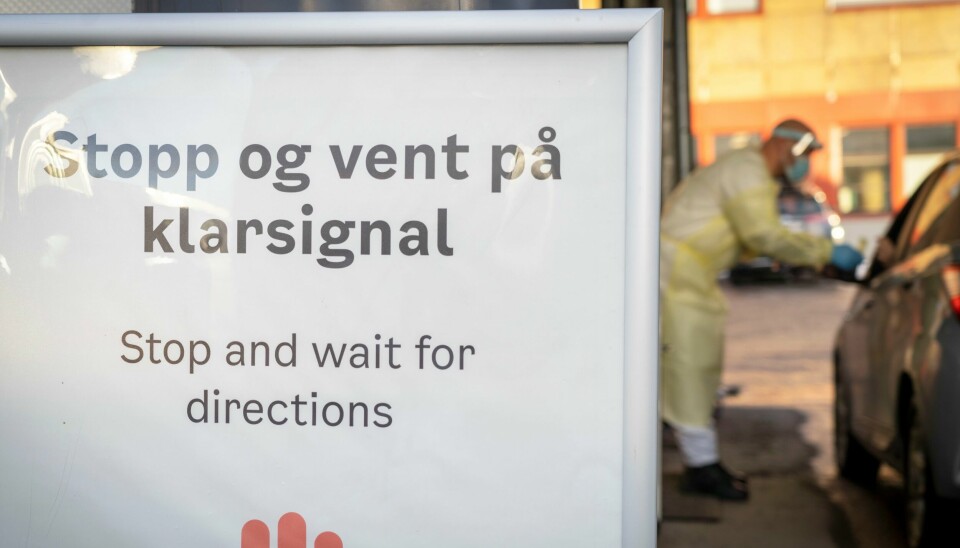 Koronatesting på Rommen i Oslo. Bildet viser en person i frakk som tester en person i bil for korona.Foto: Ole Berg-Rusten / NTB