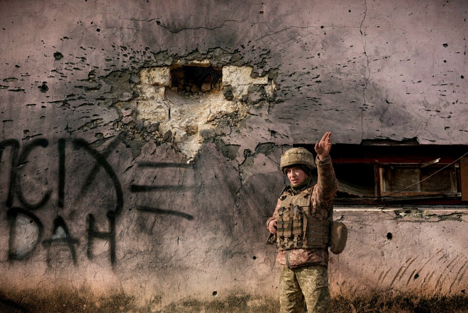 En ukrainsk soldat viser fram en bygning som ble truffet av et granatangrep nær frontlinjen i Donbass. En ukrainsk soldat viser fram en bygning som ble truffet av et granatangrep nær frontlinjen i Donbass.