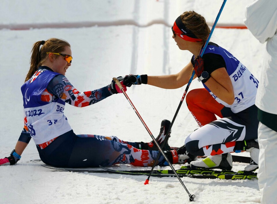 Sølvvinner Vilde Nilsen (t.v.) og gullvinner Natalie Wilkie fra Canada etter sprintfinalen i langrenn i Paralympics. Beijing 2022 Winter Paralympic Games - Para Cross-Country Skiing - Women's Sprint Free Technique Standing Final - National Biathlon Centre, Zhangjiakou, China - March 9, 2022. Gold medallist Natalie Wilkie of Canada celebrates with Silver medallist Vilde Nilsen of Norway after competing. REUTERS/Gonzalo Fuentes