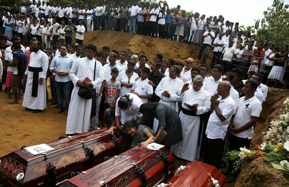 En kvinne bryter sammen ved kistene under en massebegravelse av ofre etter terroraksjonen mot tre kirker og tre hoteller i Sri Lanka søndag.