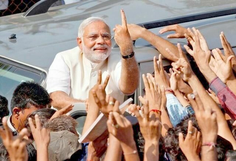 Narendra Modi viser blekket på fingeren, som bekrefter at han har stemt, til sine tilhengere utenfor et valglokale i India 30. april. Nå blir han landets nye statsminister. FOTO: AMIT DAVE/REUTERS/NTB SCANPIX