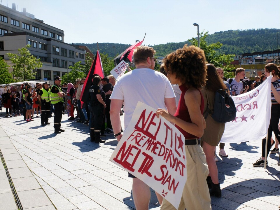 Plakater, latter og taktfaste rop som 'Ingen rasister i våre gater' ble etter et par timer tilført en hissigere tone, der 'Hold kjeft' og 'Allahu Akhbar' målbar provoserte tilhøreres frustrasjon. Da politiet til slutt ba SIAN pakke sammen, samlet publikum seg i 'Hadet bra'-rop og vinking med flagg. Oppbudet av motdemonstranter er stort og tiltar mens SIANs representanter taler på Strømsø torg 15. juni 2019. FOTO: KATRINE STRØM