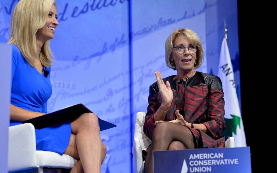 Her fra 2017. (FILES) In this file photo Education Secretary Betsy DeVos (R) makes remarks as moderator Kayleigh McEnany(L) listens during a discussion at the Conservative Political Action Conference (CPAC) at National Harbor, Maryland, February 23, 2017. - Kayleigh McEnany, a former Fox News figure who is fiercely loyal to President Donald Trump, took over April 15, 2020 as his new press secretary, entering the high-profile job at a time of turmoil in White House relations with the press. McEnany, 31, made the formal announcement a week after her predecessor Stephanie Grisham stepped down. (Photo by Mike Theiler / AFP)