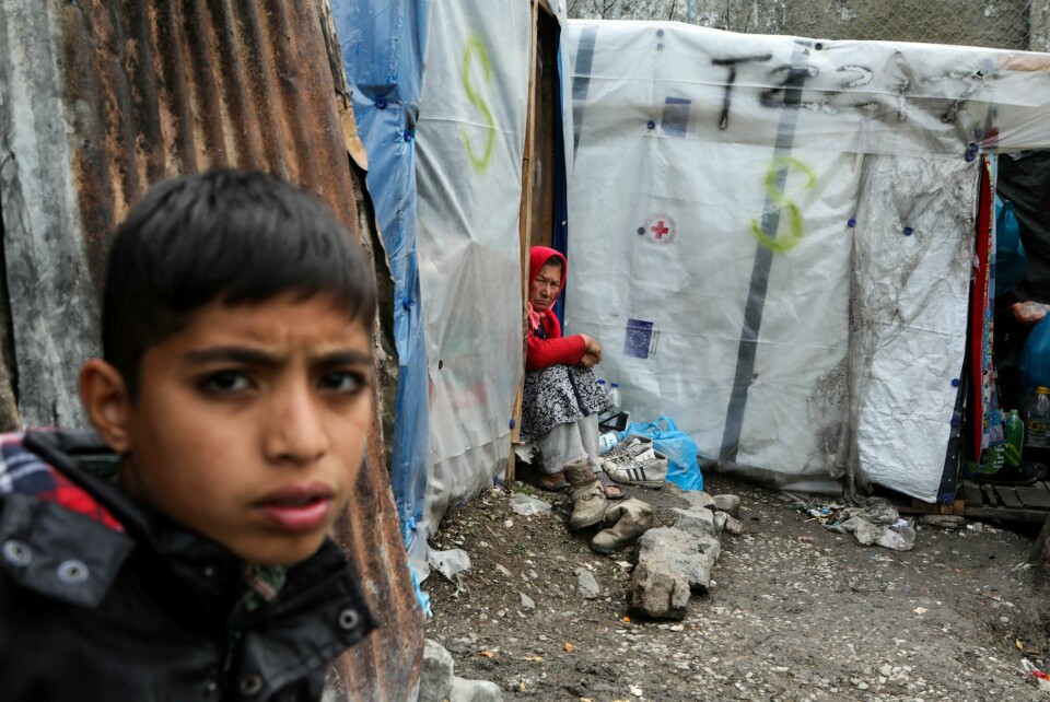 FILE PHOTO: Migrants stand outside a temporary shelter in a makeshift camp for refugees and migrants next to the Moria camp, during a nationwide lockdown to contain the spread of the coronavirus disease (COVID-19), on the island of Lesbos, Greece April 02, 2020. REUTERS/Elias Marcou/File Photo FILE PHOTO: Migrants stand outside a temporary shelter in a makeshift camp for refugees and migrants next to the Moria camp, during a nationwide lockdown to contain the spread of the coronavirus disease (COVID-19), on the island of Lesbos, Greece April 02, 2020. REUTERS/Elias Marcou/File Photo