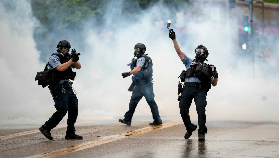 Politiet brukte tåregass for å spre demonstrantene som samlet seg utenfor politistasjonen i Minneapolis. A police officer throws a tear gas canister towards protesters at the Minneapolis 3rd Police Precinct, following a rally for George Floyd on Tuesday, May 26, 2020, in Minneapolis. Four Minneapolis officers involved in the arrest of Floyd, a black man who died in police custody, were fired Tuesday, hours after a bystander's video showed an officer kneeling on the handcuffed mans neck, even after he pleaded that he could not breathe and stopped moving. (Richard Tsong-Taatarii/Star Tribune via AP)