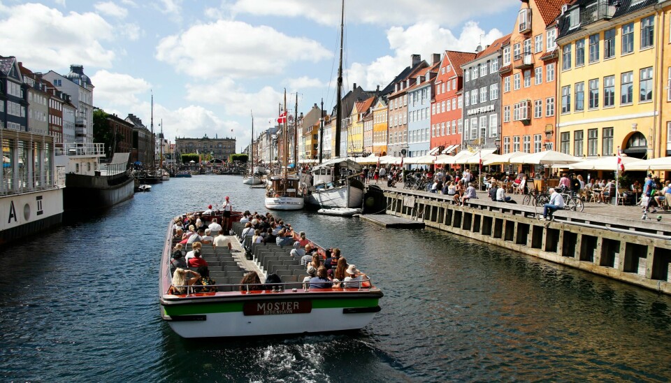 En sightseeingbåt på vei inn til Nyhavn i København, et av byens mest besøkte turistmål.