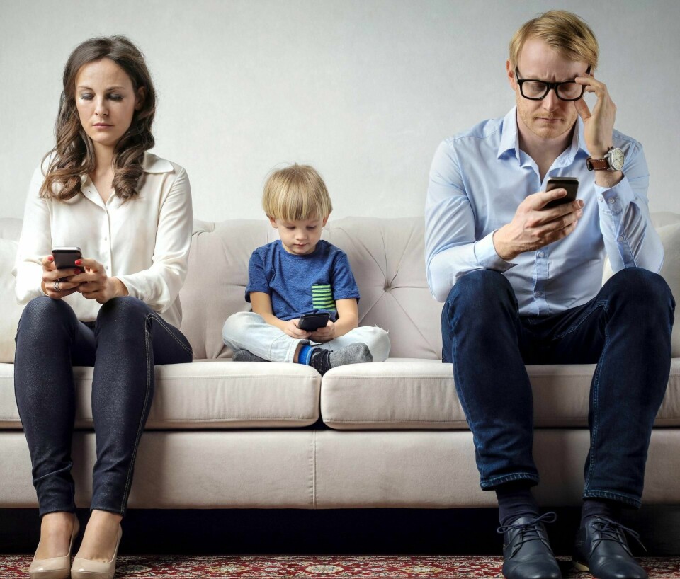 NY HVERDAG: Når vi er på våre mobile enheter snur vi oss vekk og kobler oss fra våre barn, partnere og arbeidskollegaer, skriver kronikkforfatterne. FOTO: BOWIE15/ISTOCK