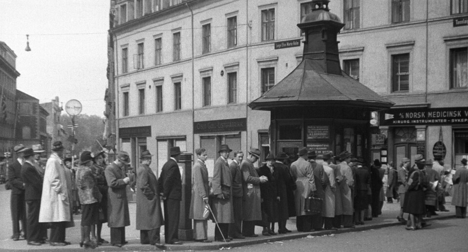 OSLO 19450509 Fredsdagene, Mai 1945. Folk i kø for å kjøpe aviser ved Narvesen-kiosken på Triangelen i Pilestredet. OSLO 19450509 Fredsdagene, Mai 1945. Folk i kø for å kjøpe aviser ved Narvesen-kiosken på Triangelen i Pilestredet.