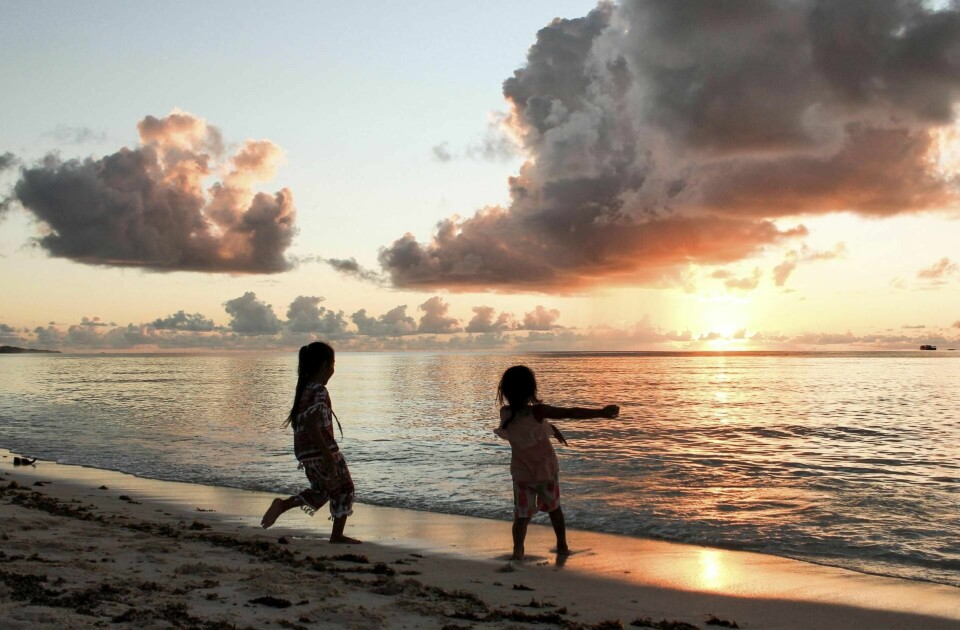 Barna leker i lagunen i Funafuti i det solen går ned og den beksvarte tropenatten kommer. Både natten og fremtiden er mørk for barna i Tuvalu.