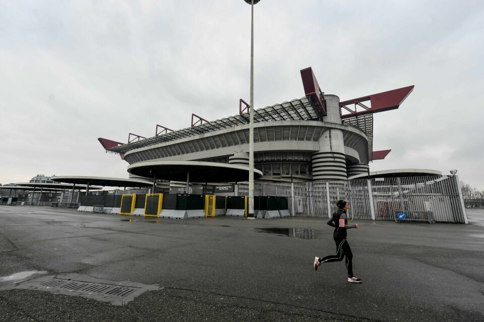 En jogger passerer San Siro i Milano der sist helgs seriekamp mellom Milan og Genoable utsatt.