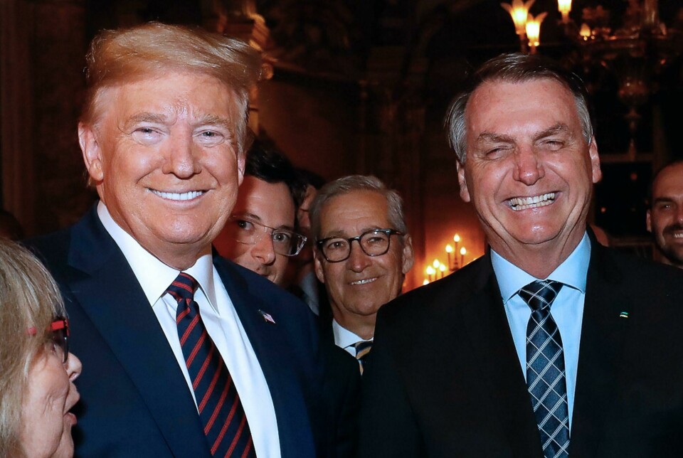 Handout picture released by the Brazilian Presidency on March 12, 2020 showing US President Donald Trump (L), Brazilian President Jair Bolsonaro (R) and his press advisor Fabio Wajngarten (2-L, behind Trump) during a dinner in Mar a Lago, Florida, United States, on March 7, 2020. - Brazilian President Jair Bolsonaro's communications chief, Fabio Wajngarten, who met US President Donald Trump last weekend at his Florida resort, has tested positive for the new coronavirus, the government said on March 12, 2020. Wajngarten, chief spokesman for the Brazilian government, travelled with Bolsonaro last Saturday to Tuesday to the United States. (Photo by Alan SANTOS / BRAZILIAN PRESIDENCY / AFP) / RESTRICTED TO EDITORIAL USE - MANDATORY CREDIT 'AFP PHOTO / BRAZIL'S PRESIDENCY / ALAN SANTOS' - NO MARKETING - NO ADVERTISING CAMPAIGNS - DISTRIBUTED AS A SERVICE TO CLIENTS Handout picture released by the Brazilian Presidency on March 12, 2020 showing US President Donald Trump (L), Brazilian President Jair Bolsonaro (R) and his press advisor Fabio Wajngarten (2-L, behind Trump) during a dinner in Mar a Lago, Florida, United States, on March 7, 2020. - Brazilian President Jair Bolsonaro's communications chief, Fabio Wajngarten, who met US President Donald Trump last weekend at his Florida resort, has tested positive for the new coronavirus, the government said on March 12, 2020. Wajngarten, chief spokesman for the Brazilian government, travelled with Bolsonaro last Saturday to Tuesday to the United States. (Photo by Alan SANTOS / BRAZILIAN PRESIDENCY / AFP) / RESTRICTED TO EDITORIAL USE - MANDATORY CREDIT 'AFP PHOTO / BRAZIL'S PRESIDENCY / ALAN SANTOS' - NO MARKETING - NO ADVERTISING CAMPAIGNS - DISTRIBUTED AS A SERVICE TO CLIENTS