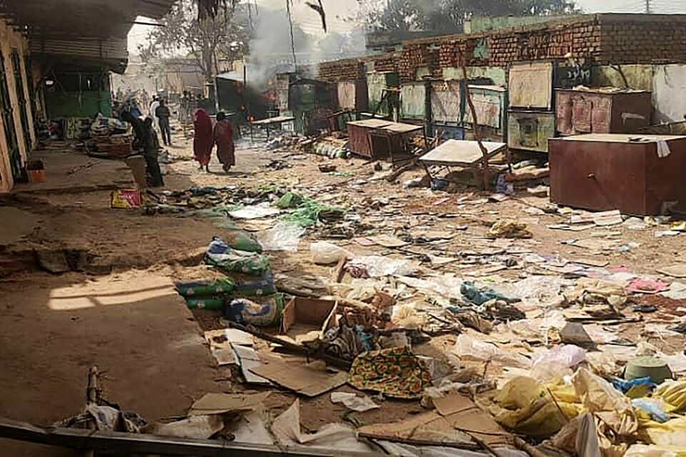 Mellom 10.000 og 15.000 mennesker har blitt drept i en denne byen, El Geneina, i Sudans krigsherjede Darfur-region siden april i fjor, melder FN. TOPSHOT - People walk among scattered objects in the market of El Geneina, the capital of West Darfur, as fighting continues in Sudan between the forces of two rival generals, on April 29, 2023. - At least 96 people were reported to have been killed in El Geneina this week, the UN said, as fierce fighting between Sudan's army and paramilitaries entered a third week, violating a renewed truce. (Photo by AFP)