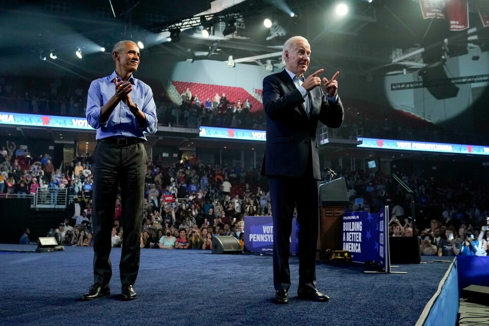 Tidligere president Barack Obama tar i et tak og hjelper sin gamle visepresident Joe Biden i valgkampen. Bildet er fra et mellomvalg i 2022. Barack Obama og Joe Biden på en scene.