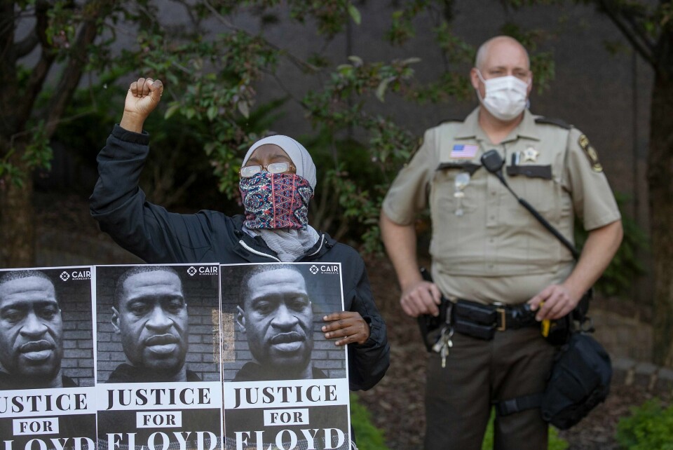 En demonstrant holder opp bilde av George Floyd, som døde etter å ha blitt pågrepet av politiet i Minneapolis. Nå er politimannen som presset kneet sitt mot halsen til Floyd, pågrepet. Foto: AP / NTB scanpix