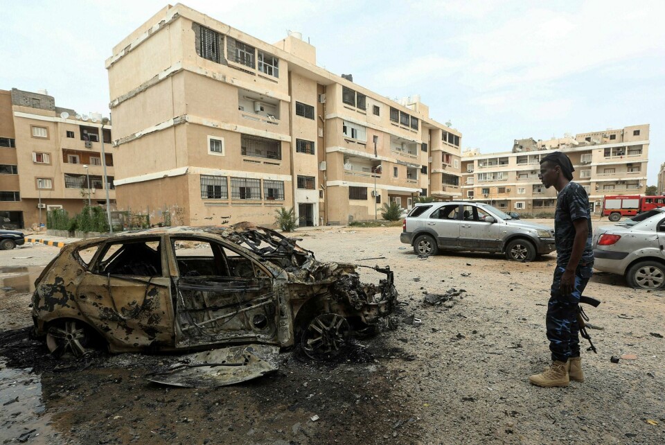 Kampene om Libyas hovedstad Tripoli har rast den siste tiden. Opprørsgeneralen Khalifa Haftar er på defensiven tross hundrevis av leiesoldater som kjemper på hans side. Den utbrendte bilen på bildet er truffet av en bombe. Soldaten tilhører den FN-støttede regjeringen i Tripoli. Foto: Mahmud Turkia / NTB scanpix