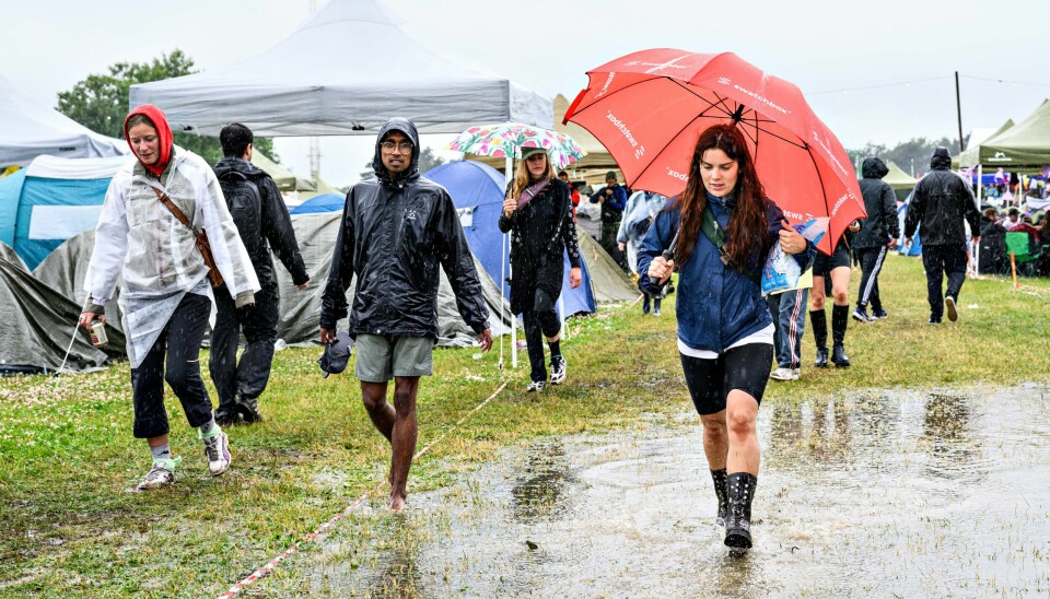 Årets Roskildefestival i Danmark er rammet av kraftig regnvær. Gummistøvler, regntøy og paraply er blitt årets festivalmote av ren nødvendighet på Roskilde, som er rammet av kraftig regnvær. Foto: Torben Christensen / Ritzau Scanpix / NTB