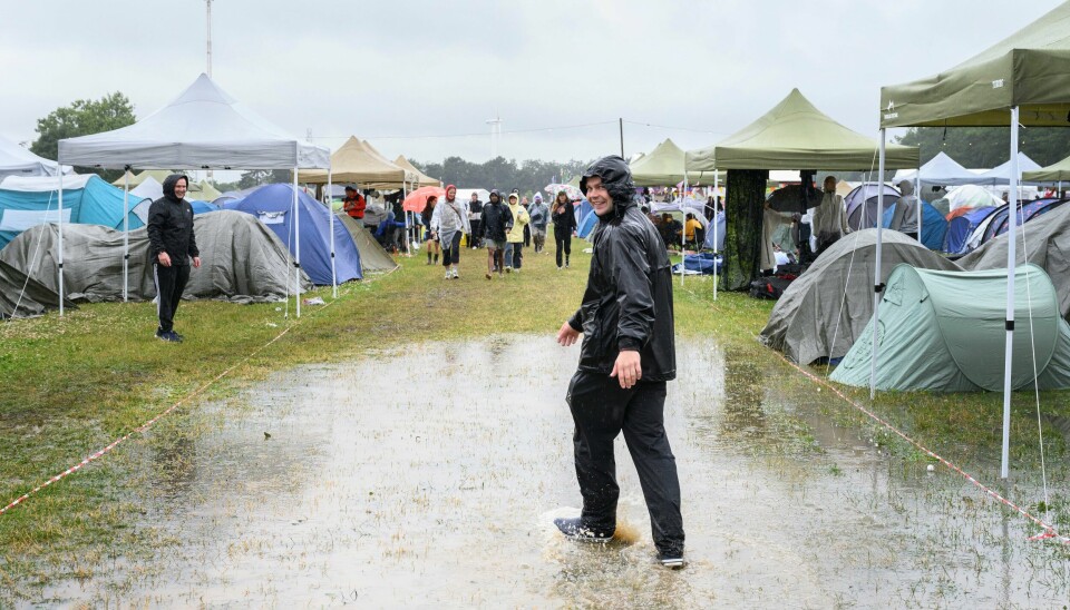 Det var vått på årets Roskilde-festival i Danmark. Smilene sitter løst til tross for at alt er klissvått på Roskildes festivalcamp søndag. Foto: Torben Christensen / Ritzau Scanpix / NTB
