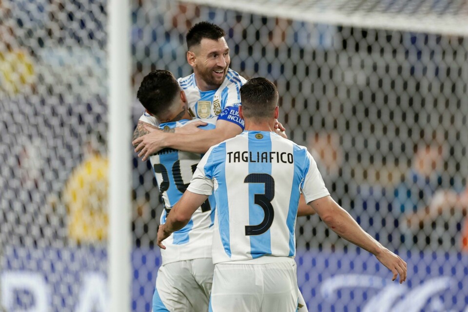 Argentinas Lionel Messi gratuleres etter å ha scoret sitt lags andre mål mot Canada under semifinalen i Copa America i East Rutherford, New Jersey, tirsdag. Foto: Adam Hunger AP / NTB Argentinas Lionel Messi gratuleres etter å ha scoret sitt lags andre mål. Han feirer sammen med to lagkamerater i Argentinas stripete drakter i hvit og lyseblå.