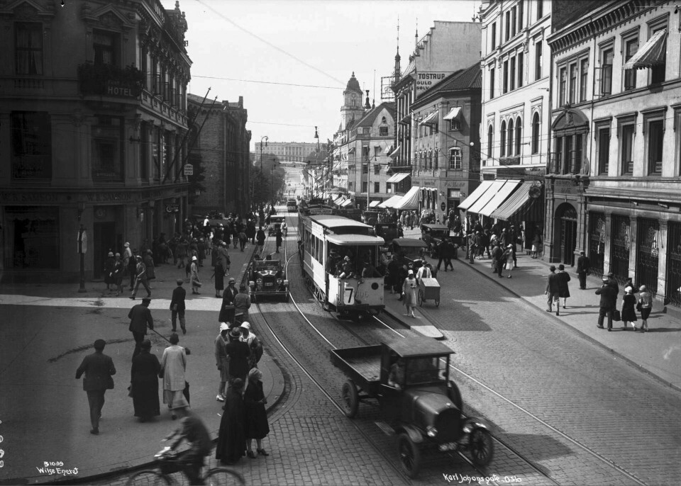 Mødrehygienekontoret lå i huset helt til venstre i bildet, ved Egertorget. Murbygg til venstre. I gata er det trikk, biler, gående og en syklist.