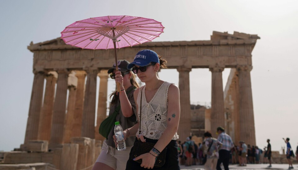 Turister med en paraply foran Parthenon ved det gamle Akropolis i Aten. Denne junimåneden har vært den varmeste som er målt i Hellas noensinne. Nå varsler meteorologer en ny hetebølge. Turister med en paraply foran Parthenon ved det gamle Akropolis i Aten. Denne junimåneden har vært den varmeste som er målt i Hellas noensinne. Nå varsler meteorologer en ny hetebølge. Foto: Petros Giannakouris / AP / NTB