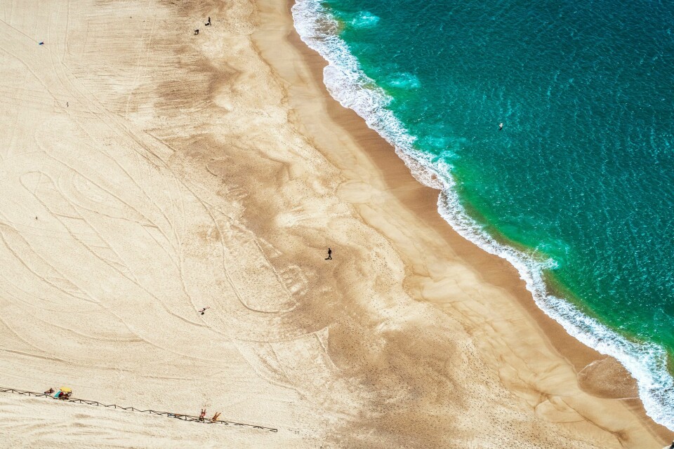 Selv om flesteparten som skal ha sommerferie skal til utlandet, som for eksempel hit til Nazaré i Portugal, så er det mange som ikke har råd til dette i år. Og mange velge rå bli hjemme. Overdreven bruk av gjødsel som siver ut i havene, er blitt et globalt problem, viser en fersk studie. Bildet viser stranden ved byen Nazaré i Portugal. Foto: Halvard Alvik / NTB