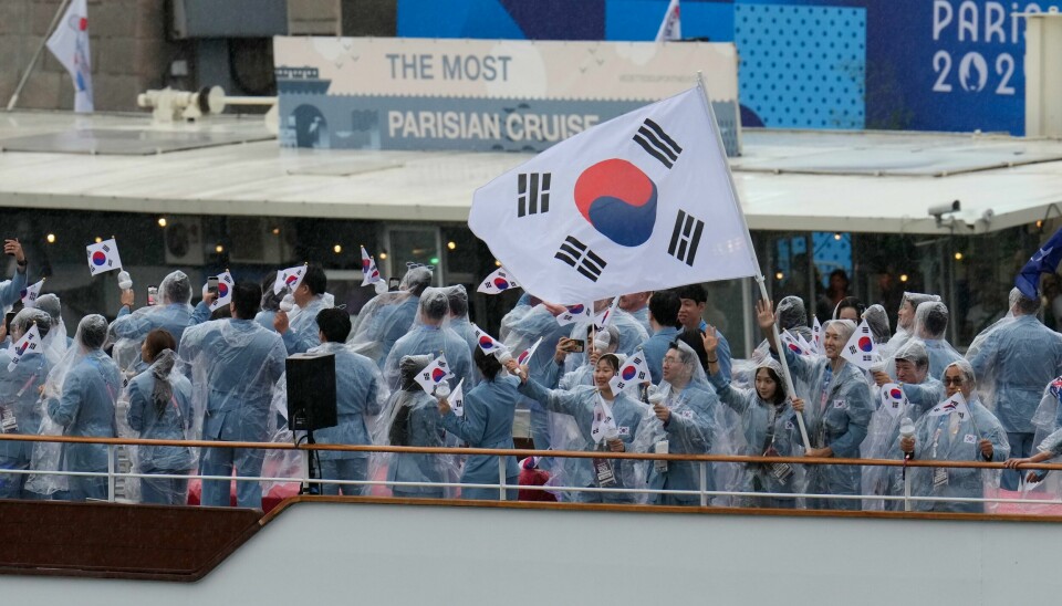 Sør-Koreas utøvere ble introdusert som Nord-Korea under OL-åpningen fredag. Her er de sørkoreanske utøverne på båten som kjørte nedover Seinen fredag. Sør-Koreas utøvere ble introdusert som Nord-Korea under OL-åpningen fredag. Her er de sørkoreanske utøverne på båten som kjørte nedover Seinen fredag. Foto: Ariana Cubillos / AP / NTB