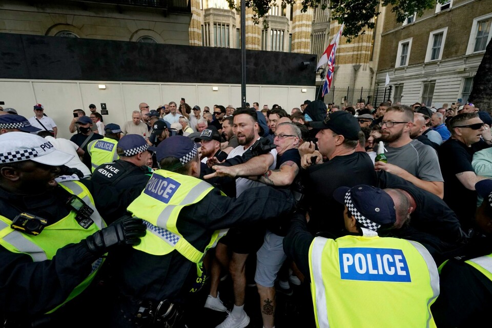 Politi og demonstranter støtte sammen på Whitehall like ved Downing Street i London onsdag kveld. Politi og demonstranter støtte sammen på Whitehall like ved Downing Street i London onsdag kveld. Foto: Jordan Pettitt / PA / AP / NTB