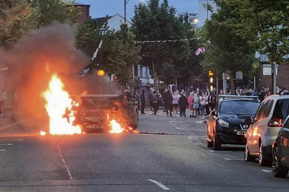 En bil er påtent under en innvandringsfiendtlig demonstrasjon i Belfast søndag. En bil er påtent under en innvandringsfiendtlig demonstrasjon i Belfast søndag. Foto: David Young / PA via AP / NTB