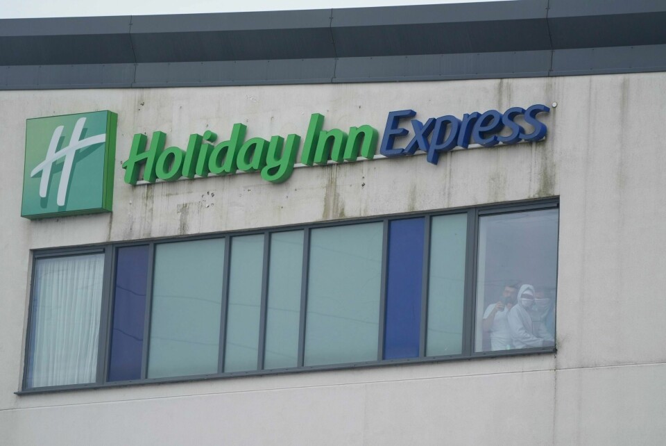 Personer inne på hotellet ser på de innvandringsfiendtlige opptøyene som pågår utenfor. Personer inne på hotellet ser på de innvandringsfiendtlige opptøyene som pågår utenfor. Foto: Danny Lawson / PA / AP / NTB