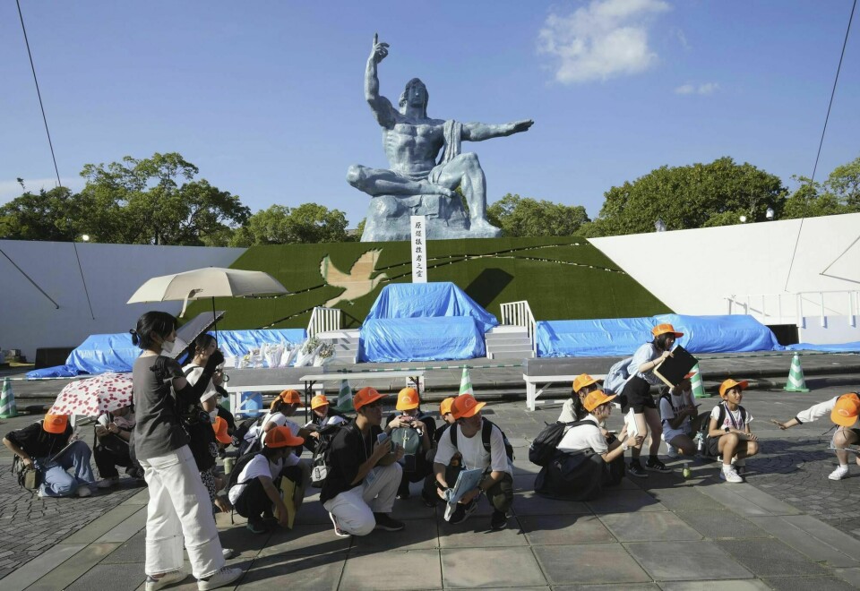 Besøkende i en fredspark i Nagasaki huker seg ned under jordskjelvet som rammet Japan torsdag. Visitors to the Peace Park crouch as an earthquake alert was issued in Nagasaki, western Japan, Thursday, Aug. 8, 2024.(Kyodo News via AP)