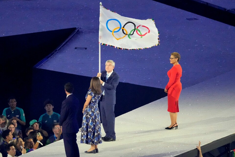 IOC-president Thomas Bach overlever flagget fra ordføreren i Paris til ordføreren i Los Angeles. OL-flagget ble gitt videre fra Paris til Los Angeles under avslutningsseremonien søndag. Her er det IOC-president Thomas Bach som holder det. Foto: Martin Meissner, AP / NTB