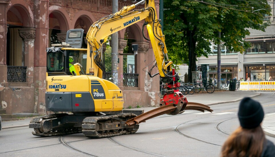 - I dag kan en spinkel kvinne med en gravemaskin gjøre mere og bedre jobb enn hundre kraftige mannfolk med hakke og spett., skriver kommentatoren. Her flyttes trikkeskinner med gravemaskin ved Kirkeristen i Oslo sentrum. Trikkeskinner som flyttes med gravemaskin ved Kirkeristen i Oslo sentrum.