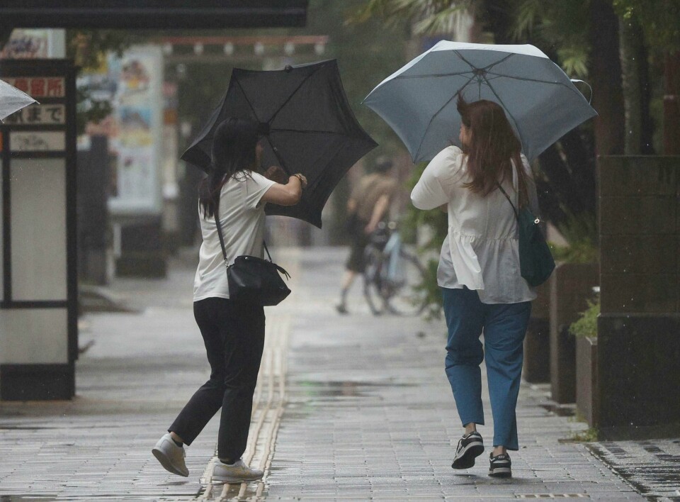 Folk sliter med å holde fast i paraplyene sine mens vinden fra tyfonen Shanshan raser i Kagoshima vest i Japan. Folk sliter med å holde fast i paraplyene sine mens vinden fra tyfonen Shanshan raser i Kagoshima vest i Japan. Foto: Hidetaka Komukai / Kyodo News via AP / NTB