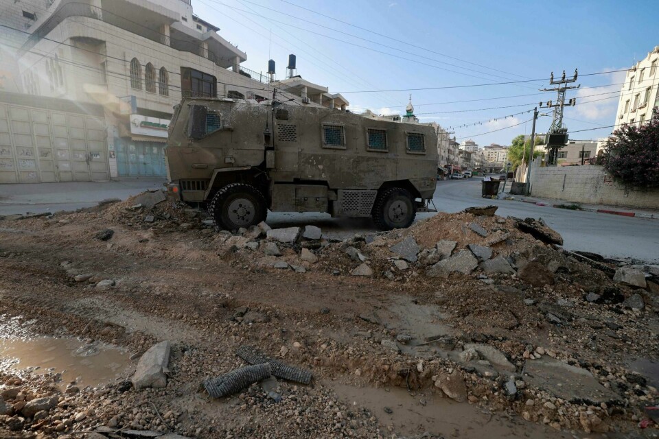 Et israelsk militærkjøretøy unde et angrep i Tulkram tidligere denne uka. An Israeli military vehicle drives down a road during a raid in northern city of Tulkarm in the occupied West Bank on August 28, 2024. The operation comes two days after Israel said it carried out an air strike on the West Bank that the Palestinian Authority reported killed five people. (Photo by Jaafar ASHTIYEH / AFP)