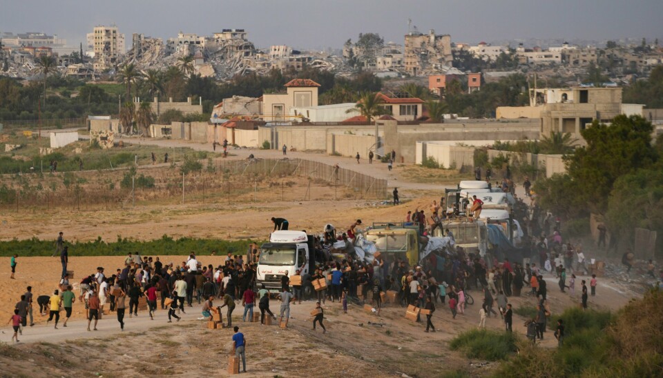 Palestinere stormer lastebiler med nødhjelp sentralt på Gazastripen i mai. Folk stimer rundt lastebiler som kommer med hjelp i mai. Foto: Abdel Kareem Hana / AP 7 NTB