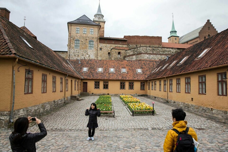 Akershus festnings lange og rike historie vil komme mer til sin rett hvis området blir en del av det levende Oslo sentrum, mener Herman Søndenaa. Bildet viser japanske turister som er på omvisning. Japanske turister poserer ved Akershus Festning.