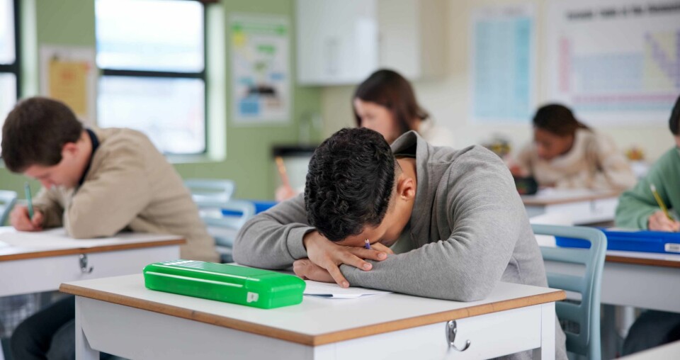 Hvis målet er at færrest mulig barn skal gå på sentralstimulerende midler (!) for å komme seg gjennom skolehverdagen, må vi også tørre å stille oss spørsmålet om hvorfor og hvordan det har blitt sånn, og om BUP og skolesystemet tilstrekkelig legger til rette for noe annet? Exam, boy and tired on desk with stress, overwhelmed and brain fog in classroom. Student, depression and overthinking in test with anxiety, burnout and mental health fatigue in high school lesson