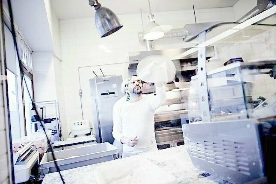 Kokken svinger pizzaen i Lofthus samvirkelag. FOTO: HILDE UNOSEN